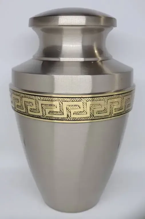 A silver urn with a gold greek key design on it.