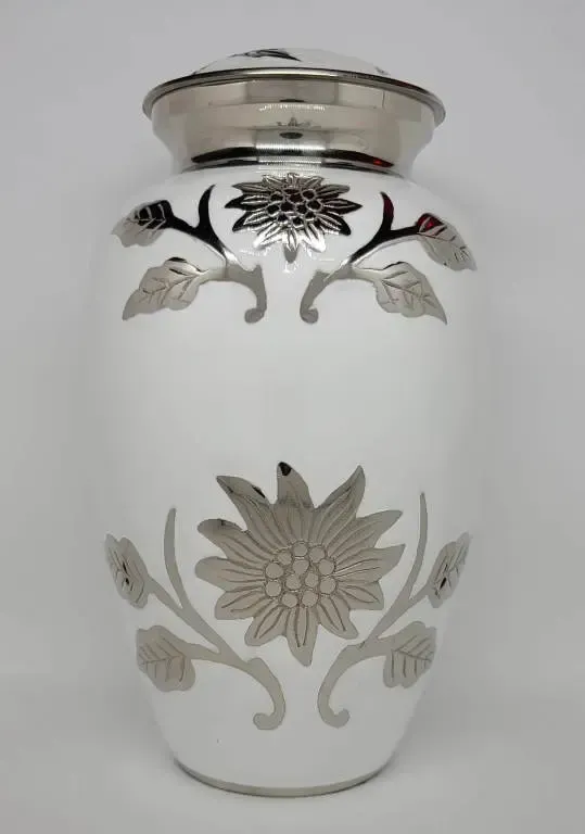 A white vase with a silver flower on it