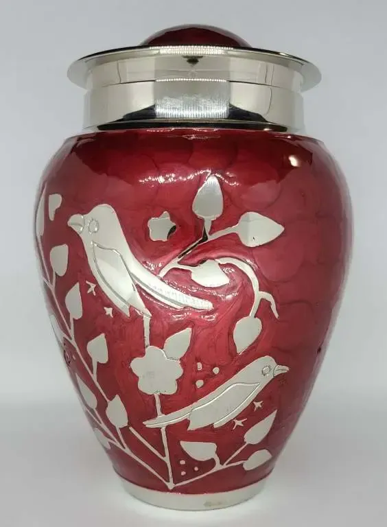 A red vase with birds and leaves on it
