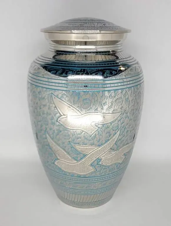 A blue urn with two birds on it is sitting on a table.