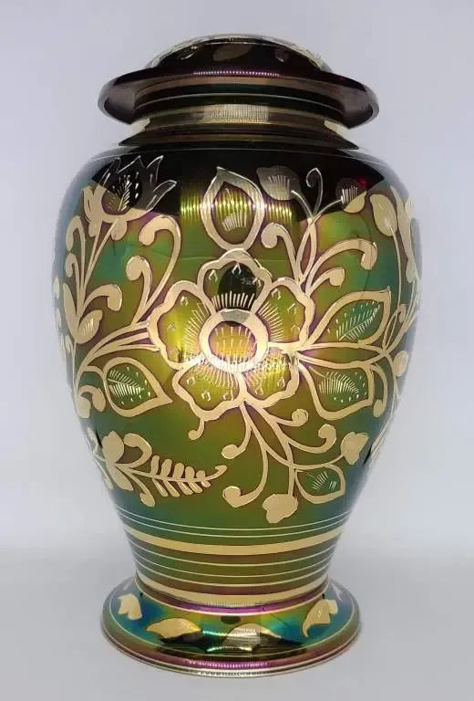 A green vase with a gold flower design on it.