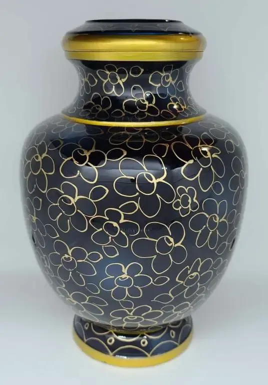 A black vase with gold flowers on it