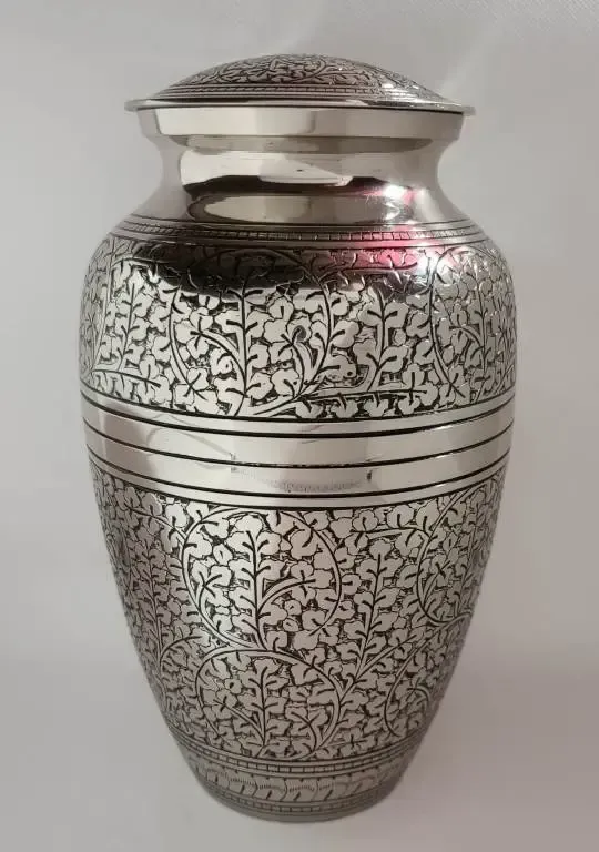 A silver vase with a floral design on it