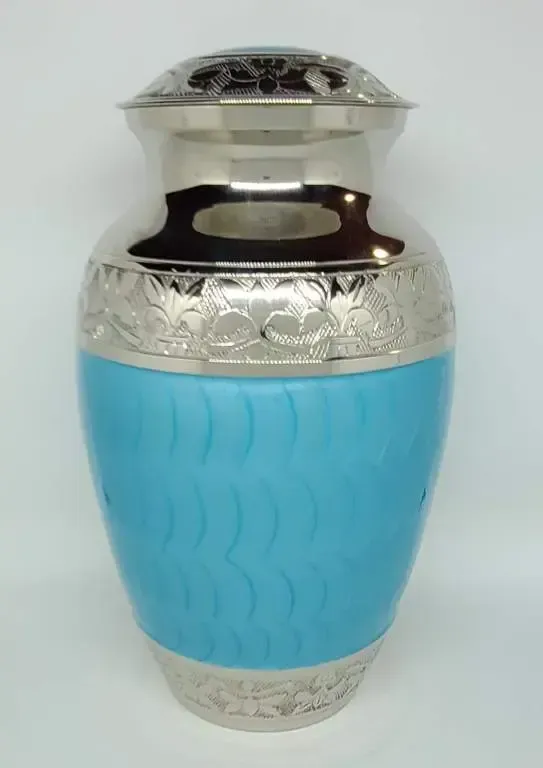 A blue and silver vase is sitting on a white surface.