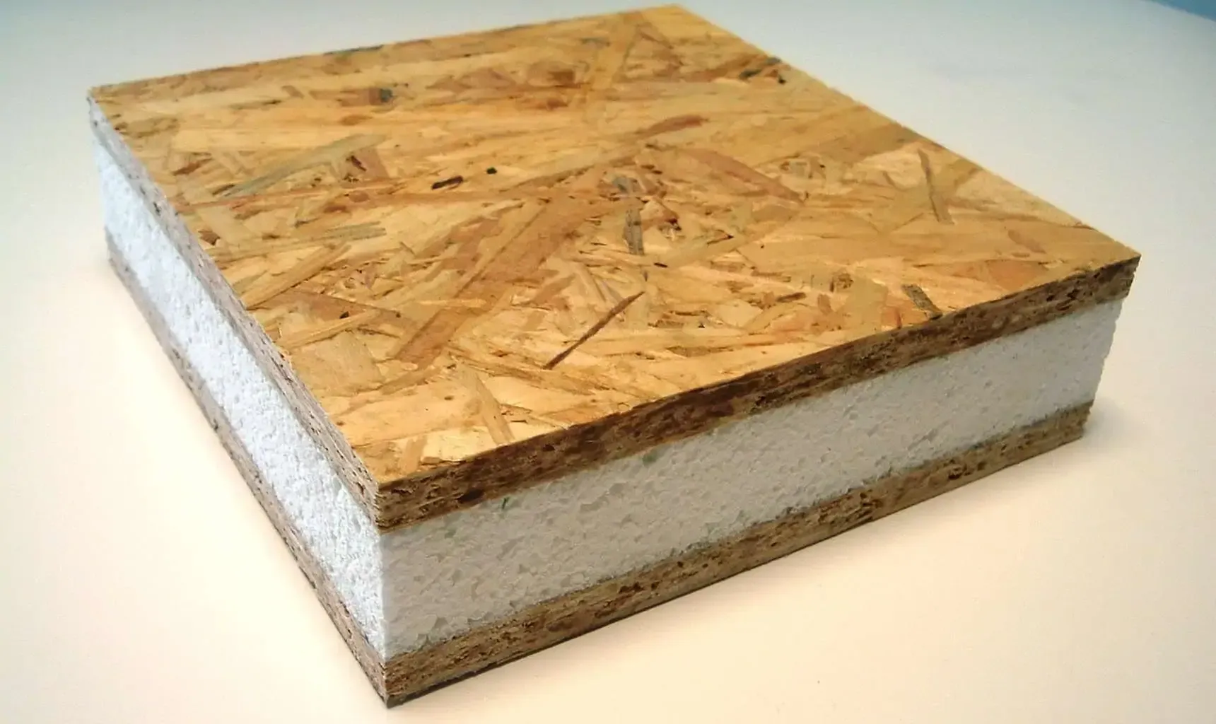 A piece of plywood and styrofoam is sitting on a table.