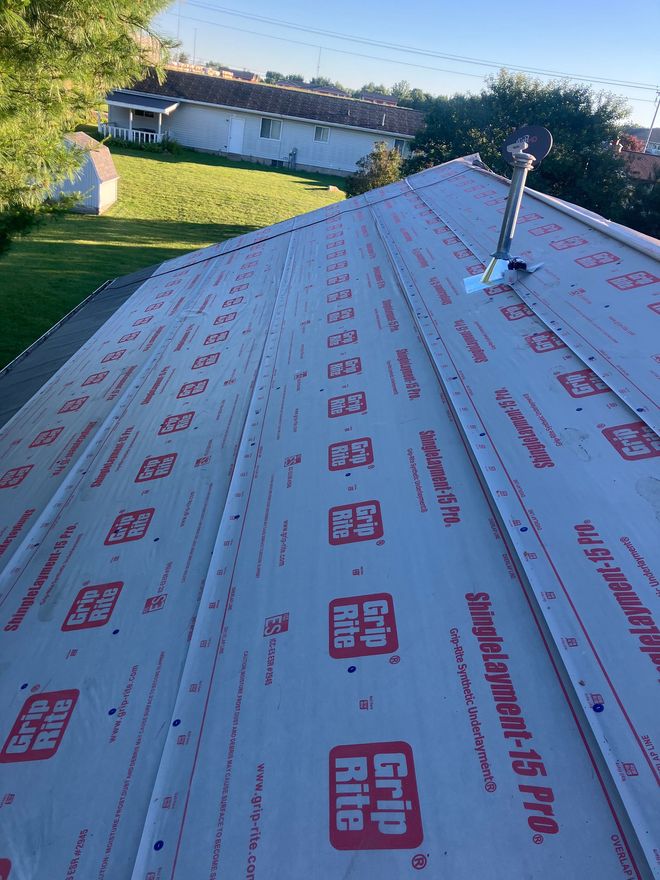 Roofing professional assessing storm damage on residential roof