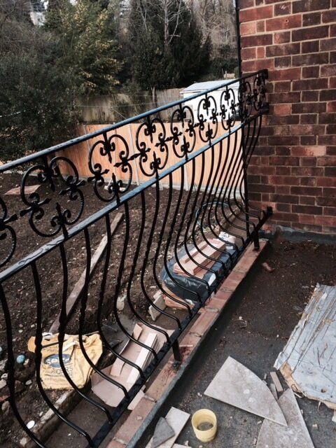 Black metal fencing being installed