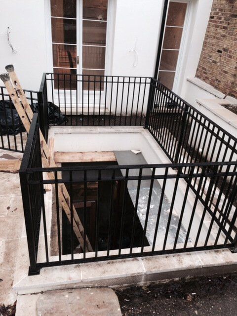 Black metal fencing surrounding ground opening