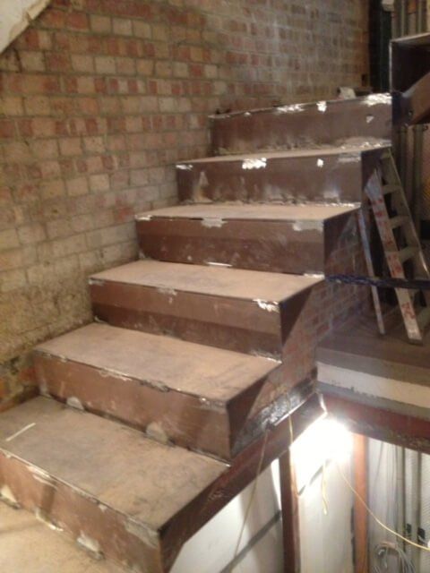 Staircase being built with decorative metal handrail