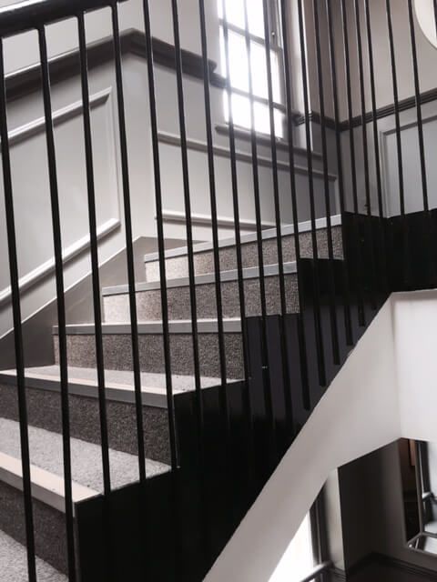 Staircase with decorative black metal handrail