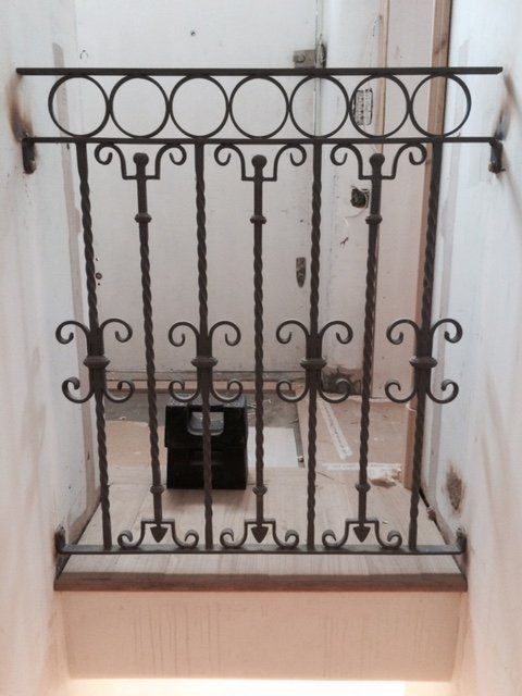 Small piece of metal fencing between two walls