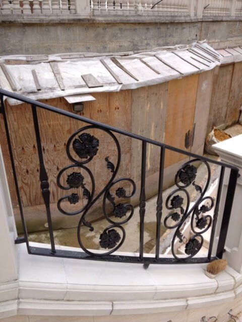 Black floral handrail on outside marble staircase