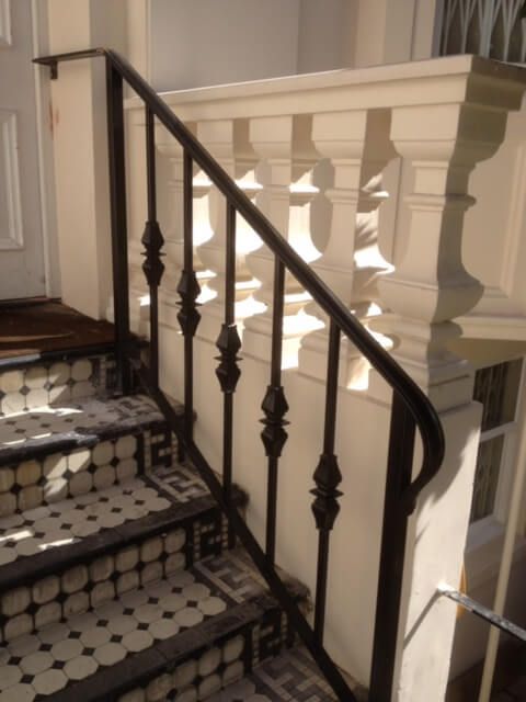 Black detailed handrail on tiled staircase