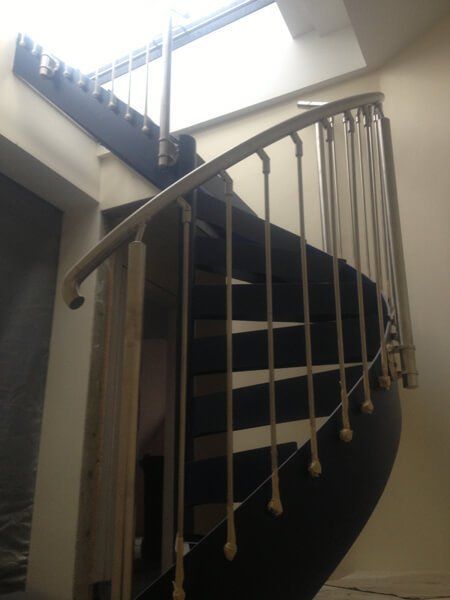 Marble spiral staircase with brushed metal handrail