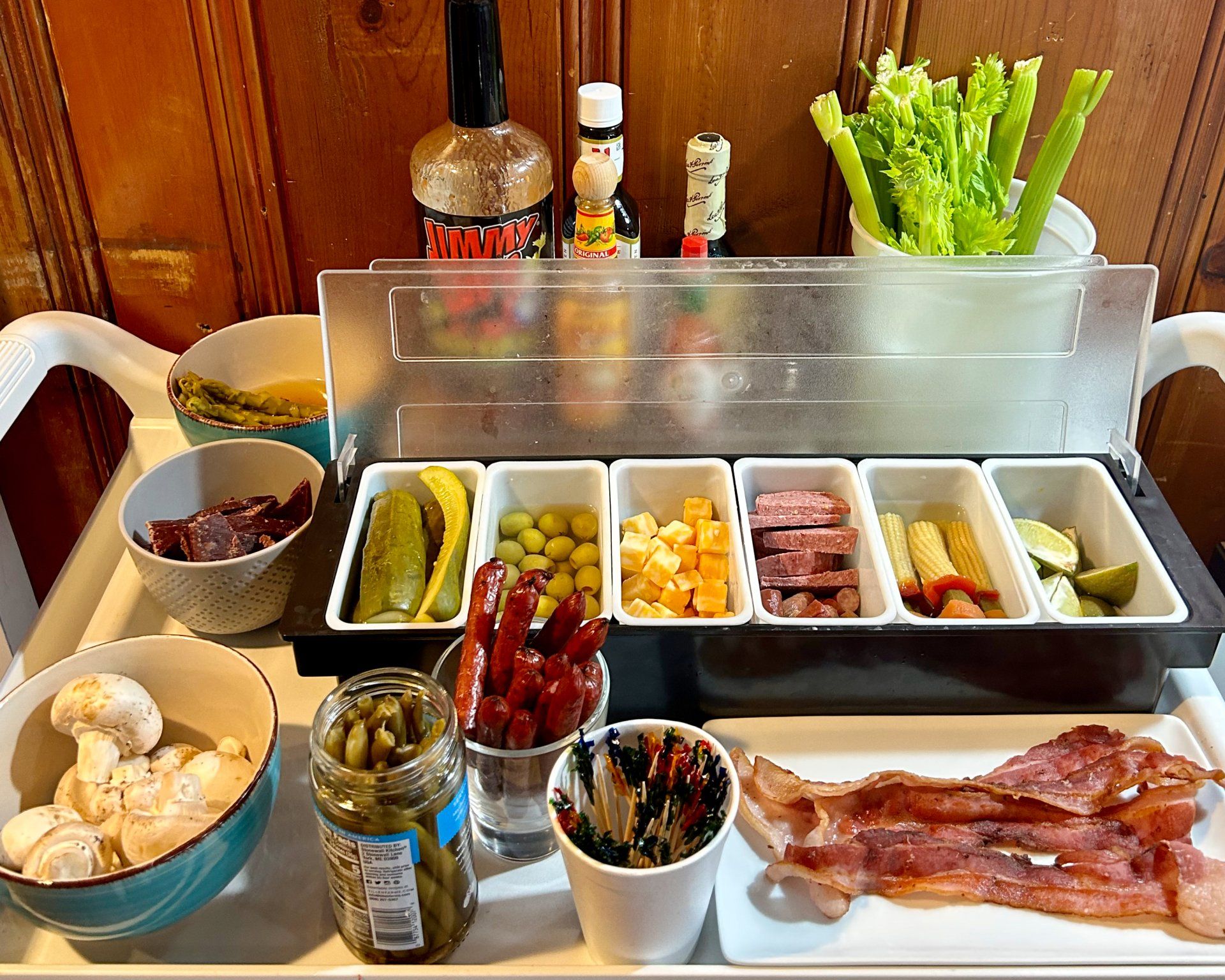 A tray with a variety of food including bacon and pickles