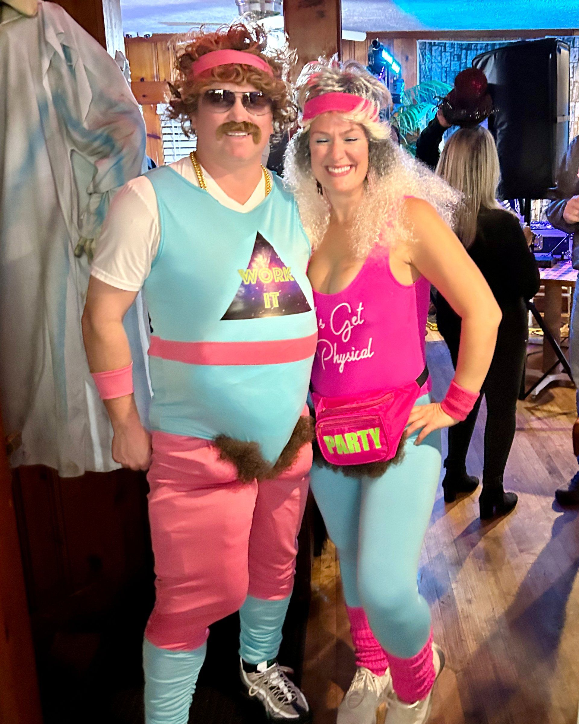 A man and a woman are posing for a picture in a room.