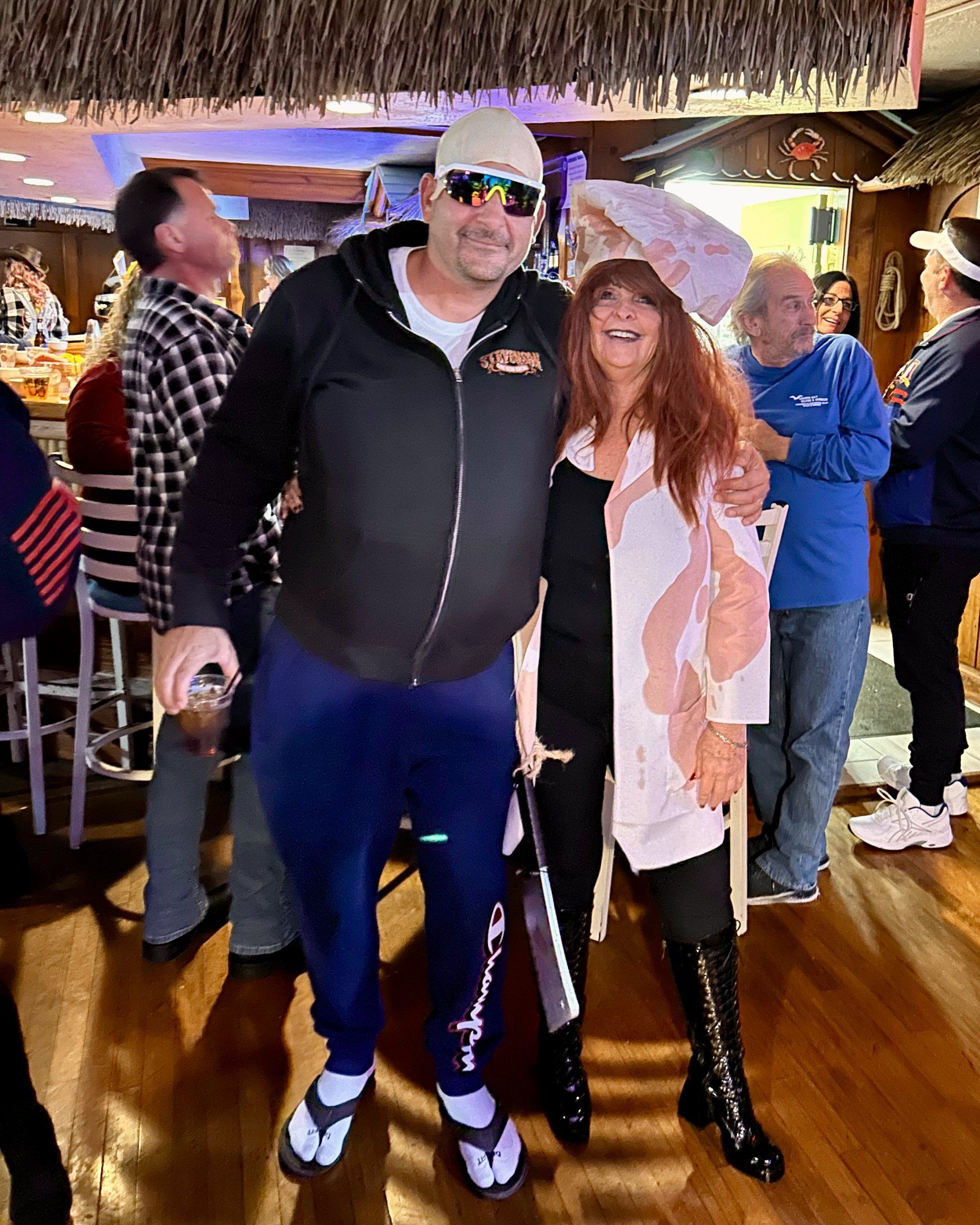 A man and a woman are posing for a picture in a bar.