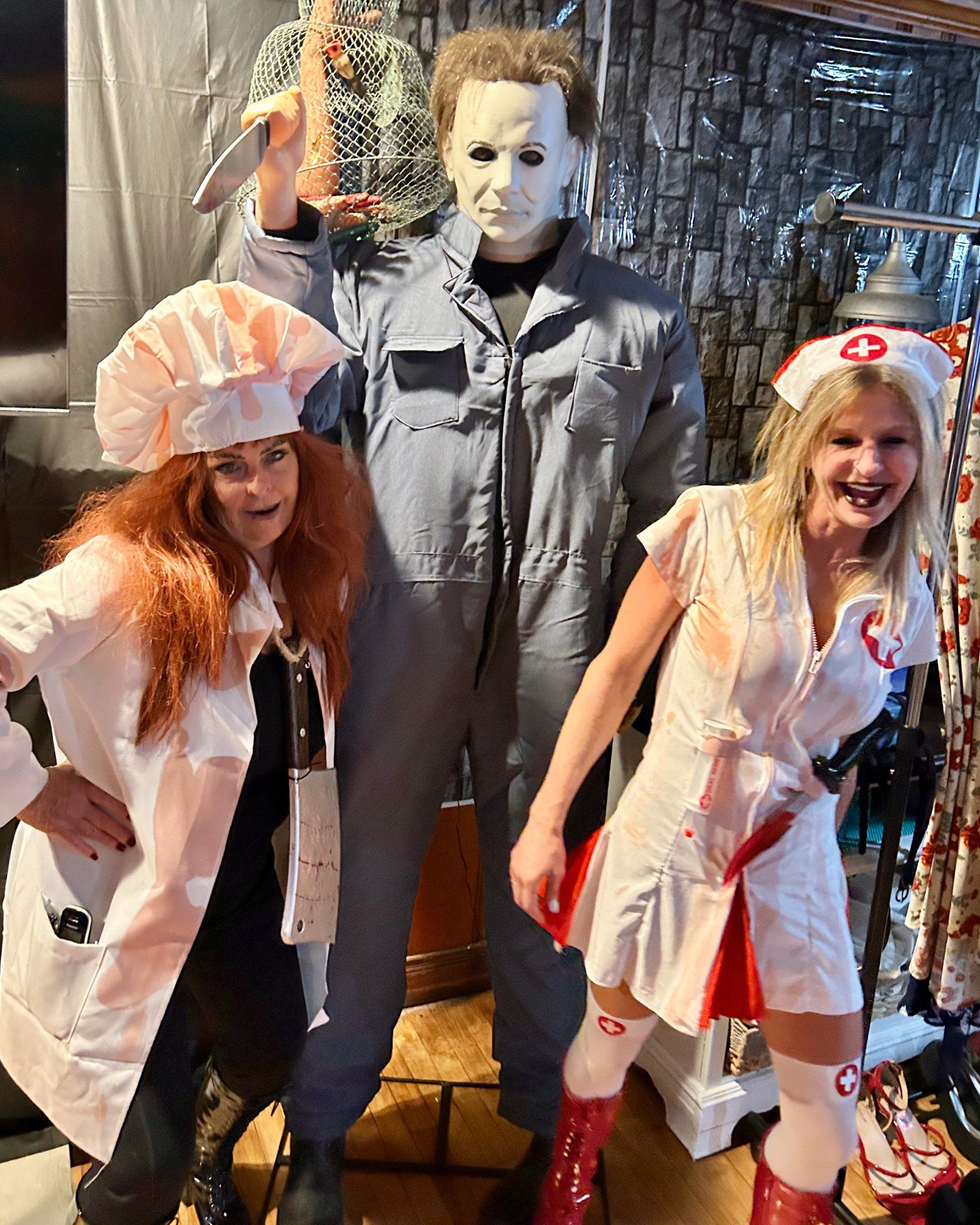 A group of people dressed in halloween costumes are posing for a picture.