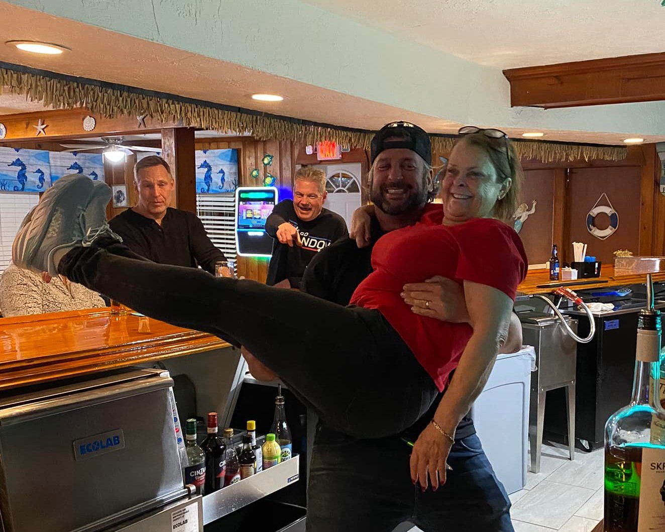 A man is holding a woman in his arms in a restaurant.