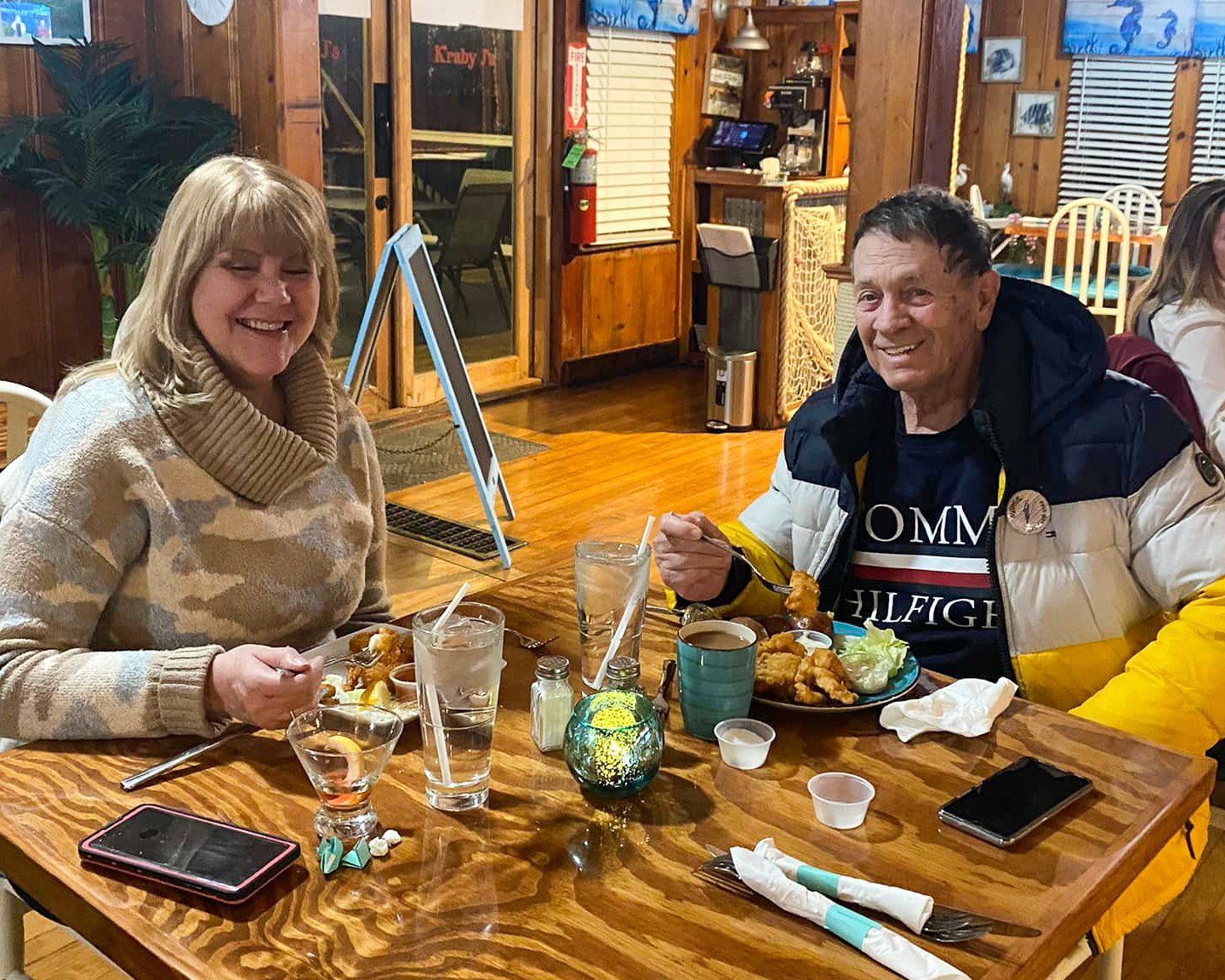 A man and a woman are sitting at a table in a restaurant eating food.