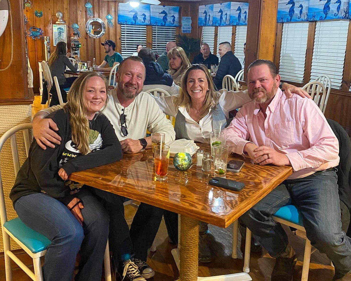 A group of people are sitting at a table in a restaurant.