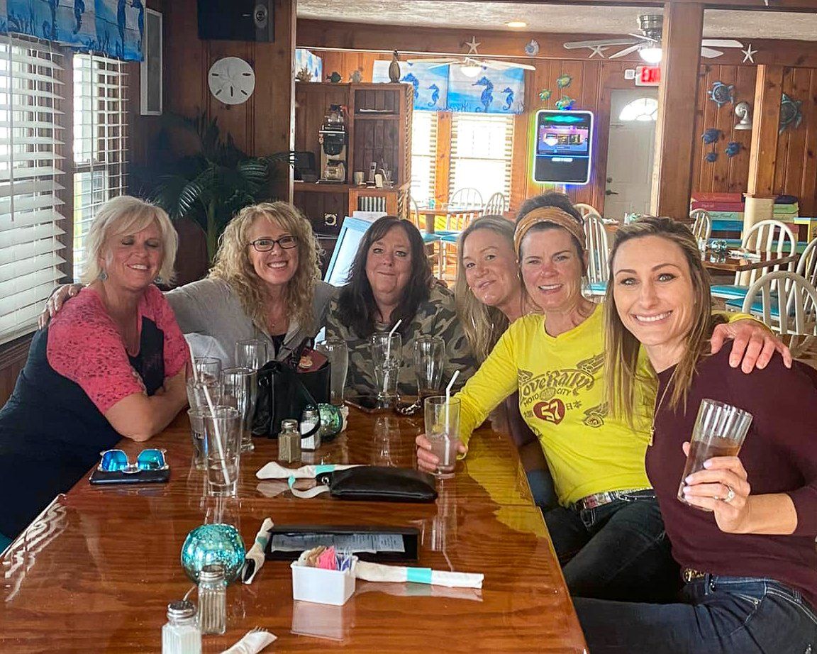 A group of women are sitting at a table in a restaurant.