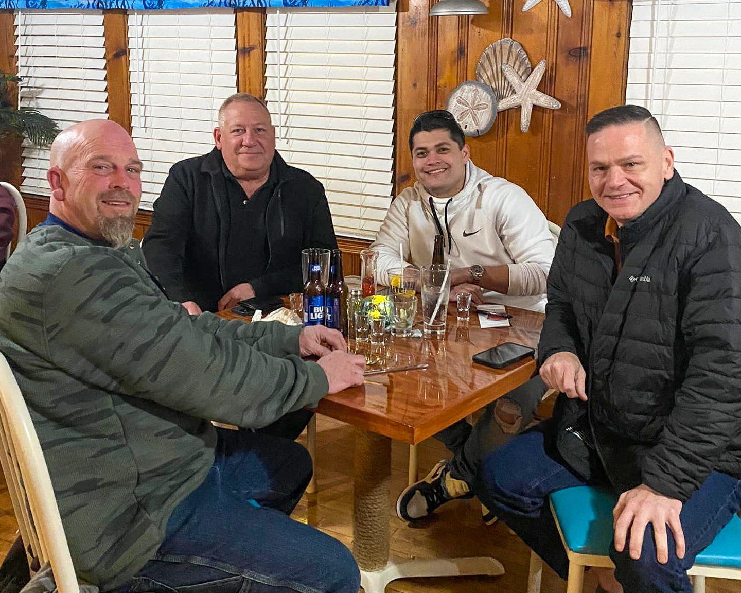 A group of men are sitting at a table in a restaurant.
