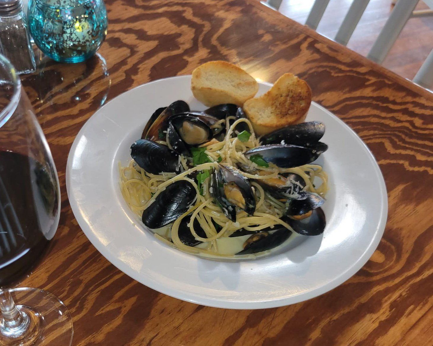 A plate of mussels and noodles on a wooden table