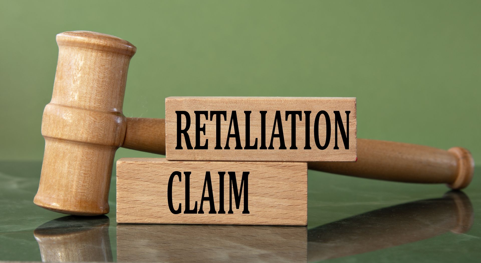Wooden legal blocks reading retaliation claim next to a gavel for a retaliation claim attorney. Wooden legal blocks reading retaliation claim next to a gavel for a retaliation claim attorney.