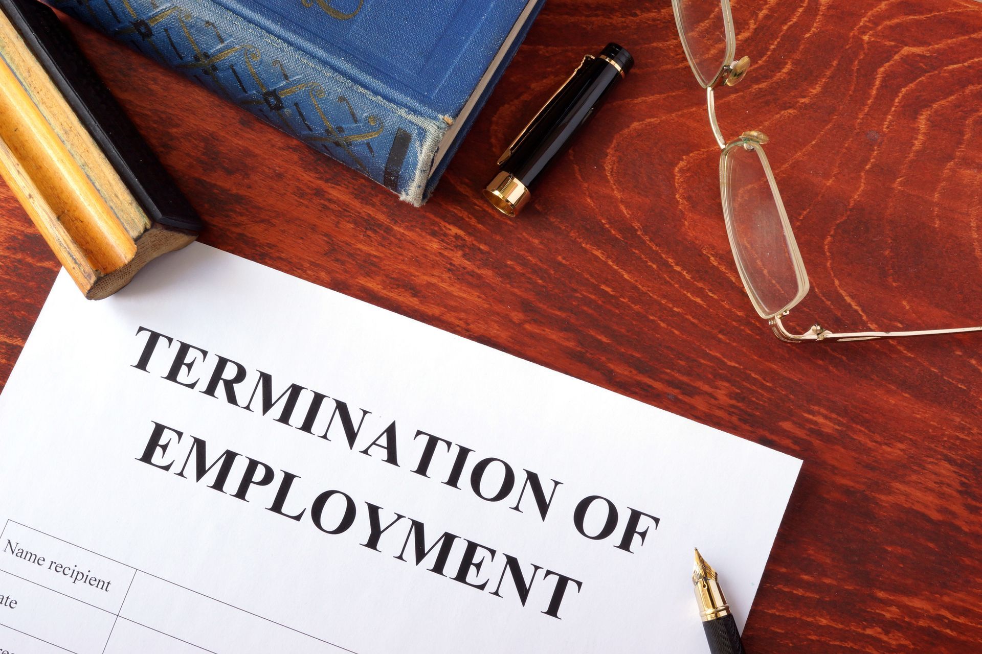 Termination of employment form on a wooden surface. Termination of employment form on a wooden surface.