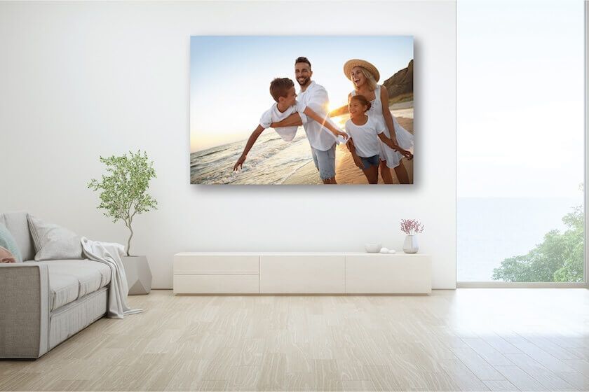 Canvas print on a wall with two people walking on the beach at sunset