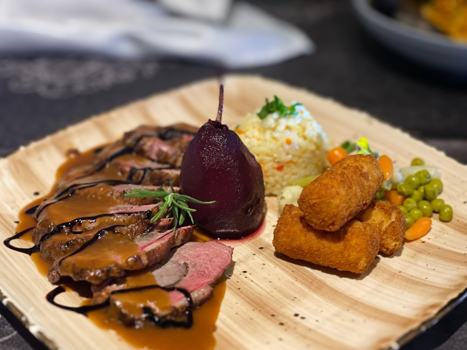 A plate of food with meat and vegetables on a table