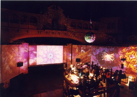 Concert stage with psychedelic visuals and disco ball lighting show