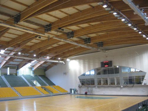 Indoor sports hall with wooden beams and empty court