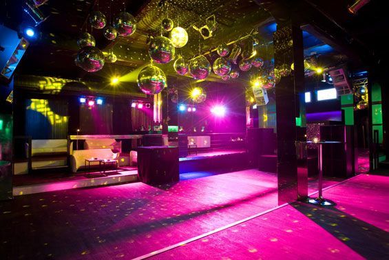 Colorful nightclub interior with disco balls and a vibrant dance floor