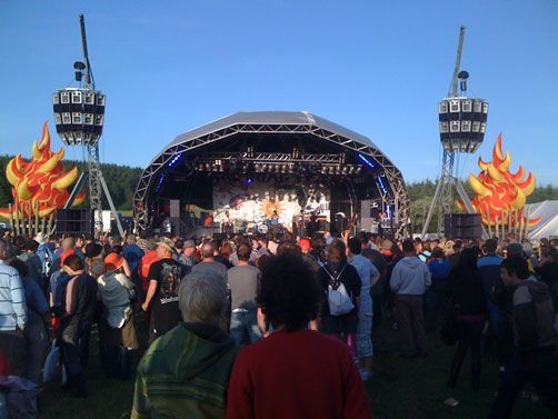 Outdoor festival stage with band and fire decorations