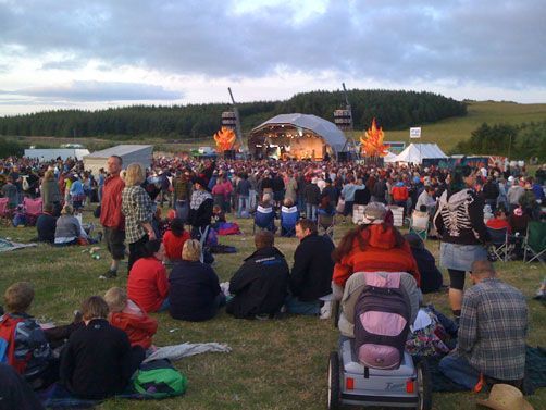 Festival crowd at outdoor stage in open field