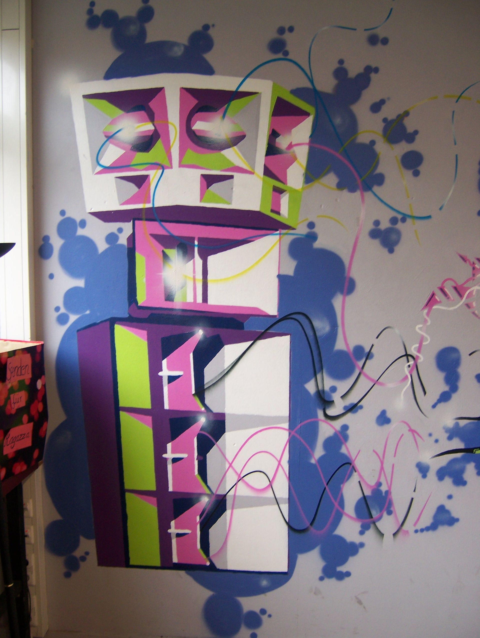 Graffiti mural of loudspeakers with colorful lines and abstract sound waves.