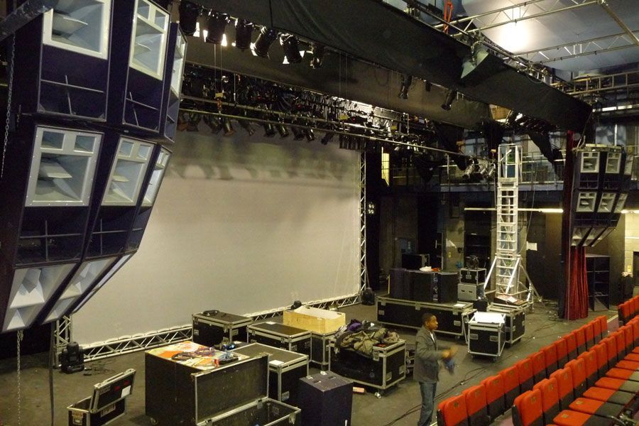 live venue setup with hanging Funktion-One speakers, stage rig, and cases.