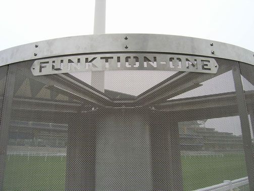 Funktion-One logo cut into a curved speaker grill at an outdoor venue.