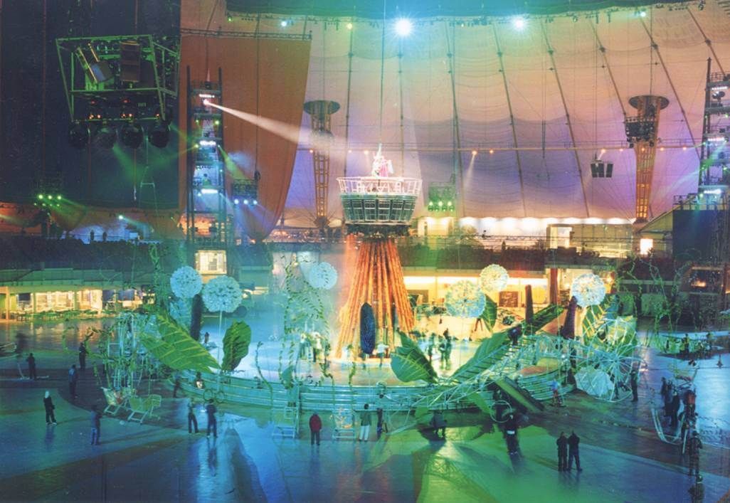 Indoor arena event setup with a colorful stage and performers