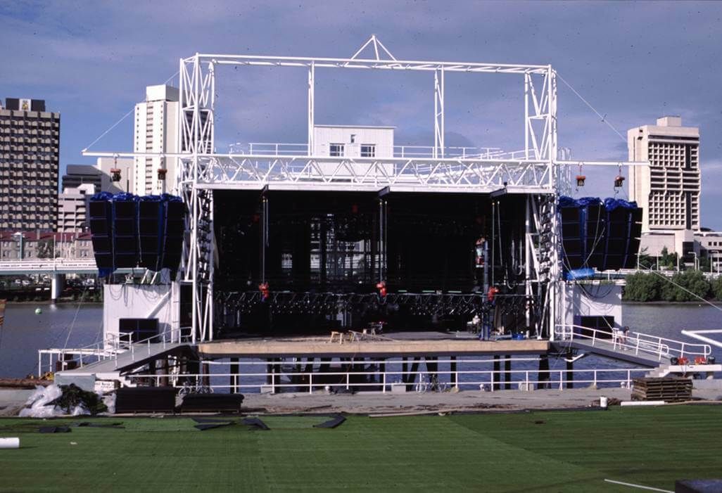 Outdoor concert stage under construction with rigging and sound system