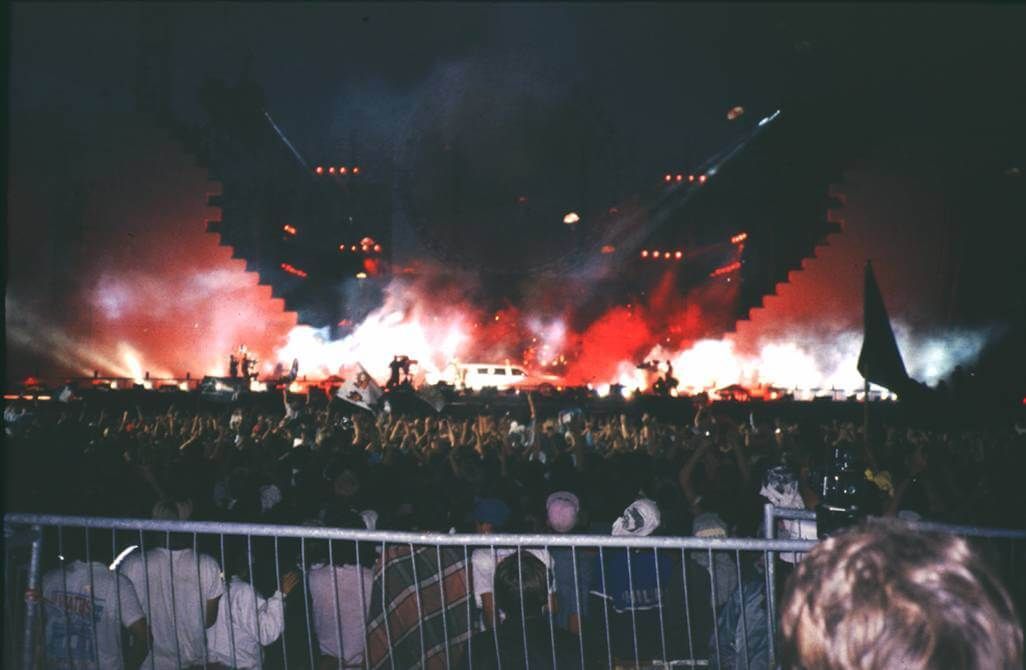 Large outdoor concert with pyrotechnics and a cheering crowd