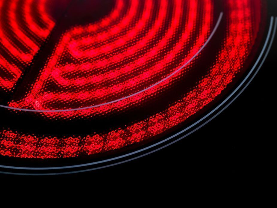 A close up of a stove top oven with red lights on it.