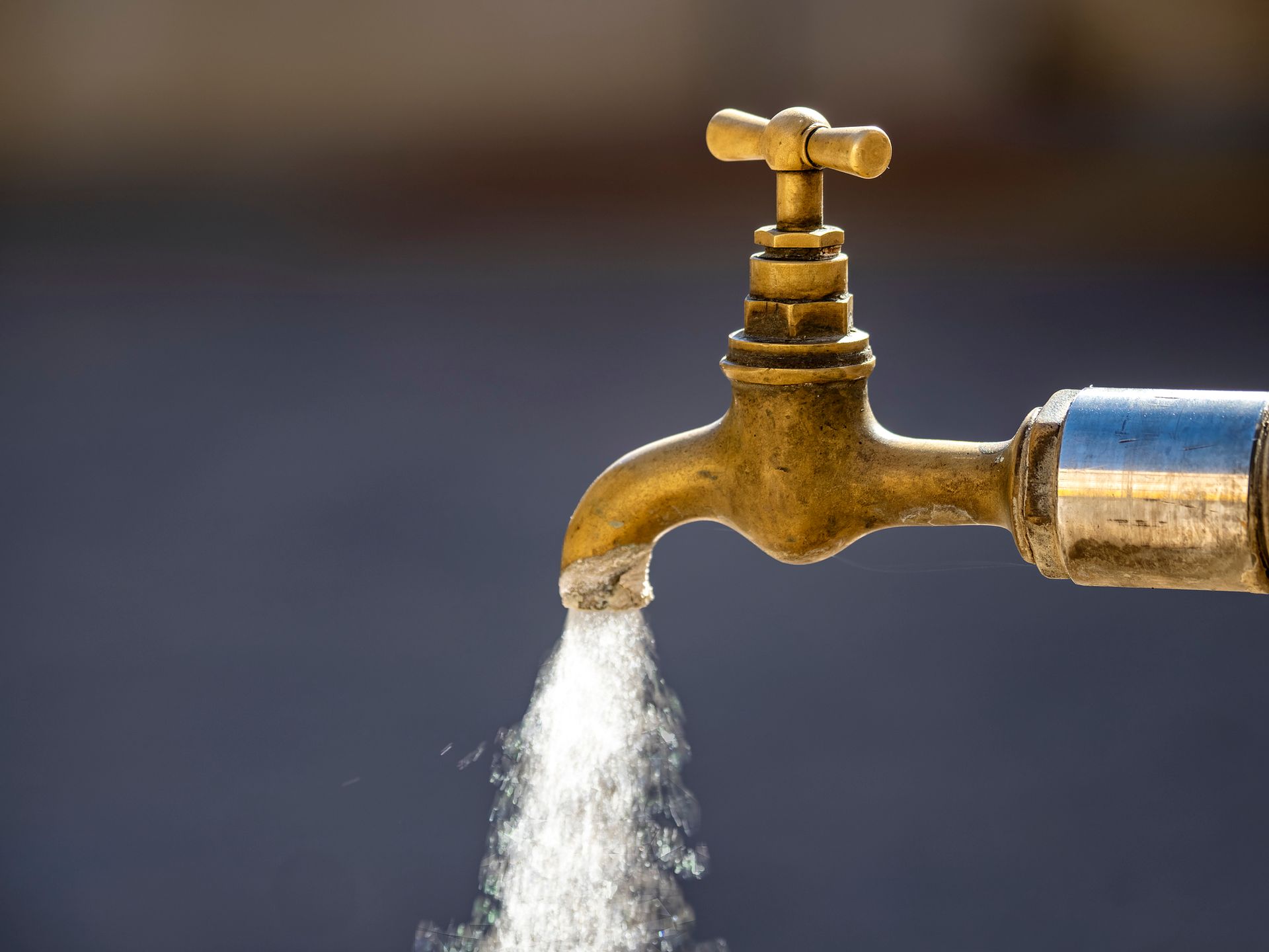 A close up of a faucet with water coming out of it