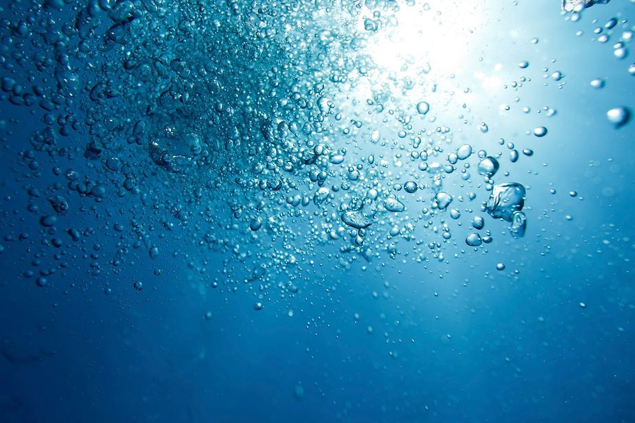 The sun is shining through the bubbles in the water.
