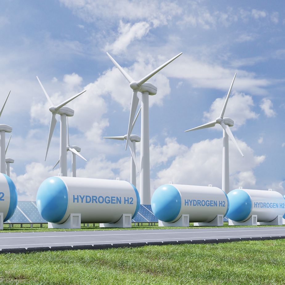 A row of hydrogen tanks next to wind turbines