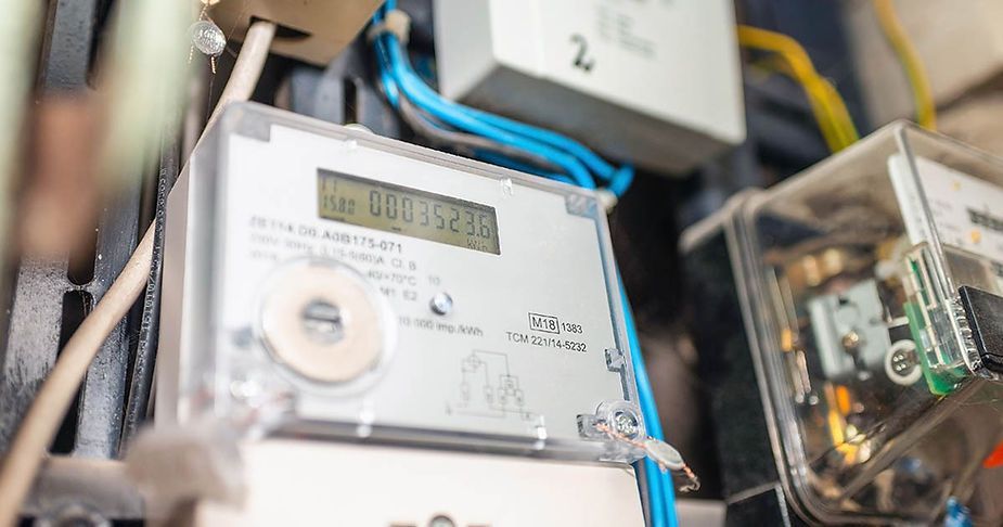 A close up of an electric meter on a wall.