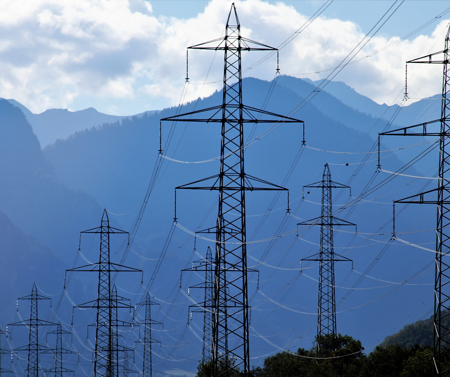 A row of power lines with mountains in the background