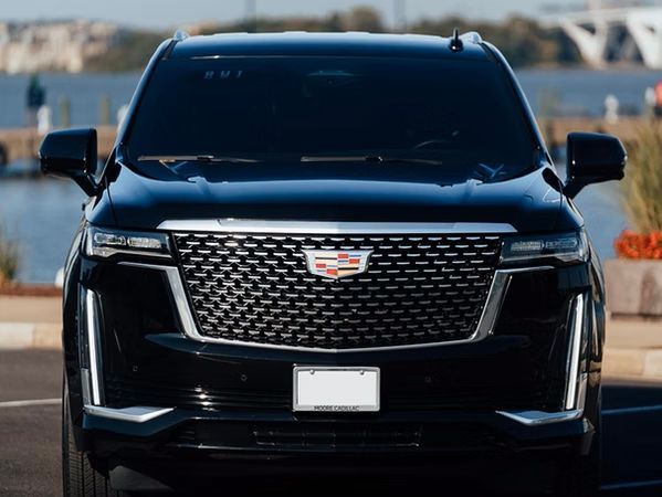 Black Cadillac Escalade SUV parked, facing forward. Front view with grille and logo visible.